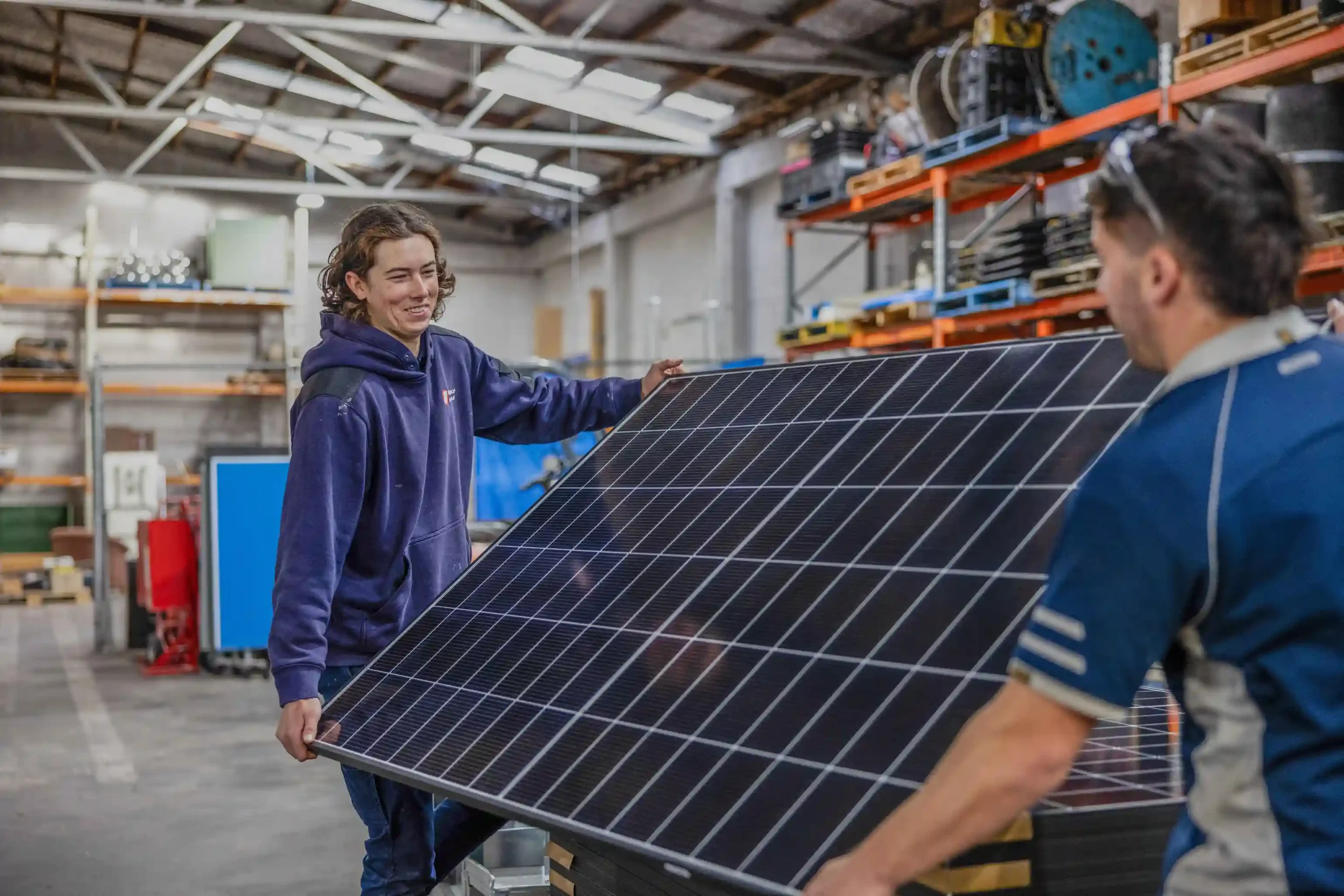 Mance electrical team carrying solar panel
